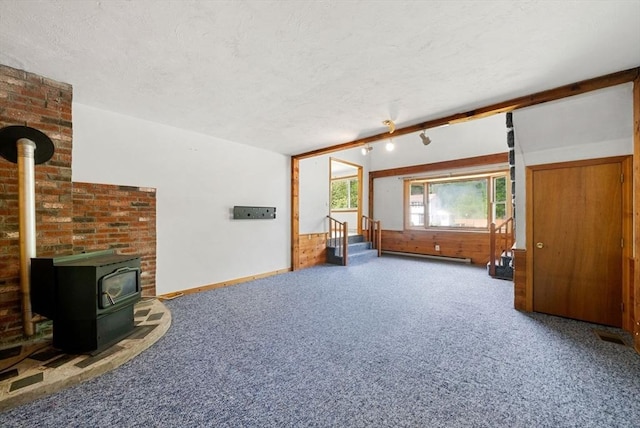 52 Richard Rd, Hanson, MA 02341 - unfurnished living room featuring a wood stove, carpet floors, a textured ceiling, vaulted ceiling, and a baseboard radiator