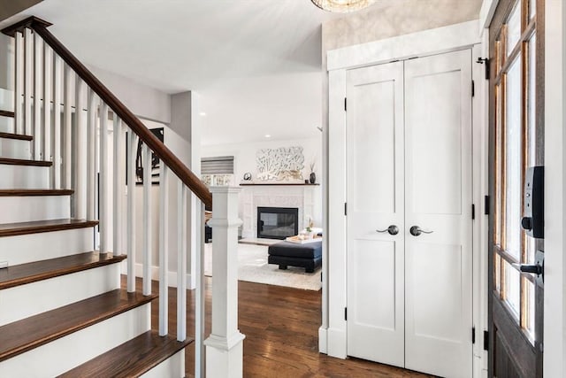 foyer entrance with plenty of natural light, dark wood-style floors, and stairs