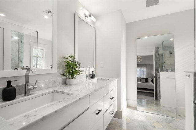 ensuite bathroom featuring a shower stall, visible vents, and a sink