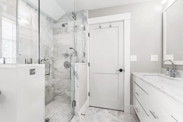 full bath with a marble finish shower, baseboards, marble finish floor, and vanity