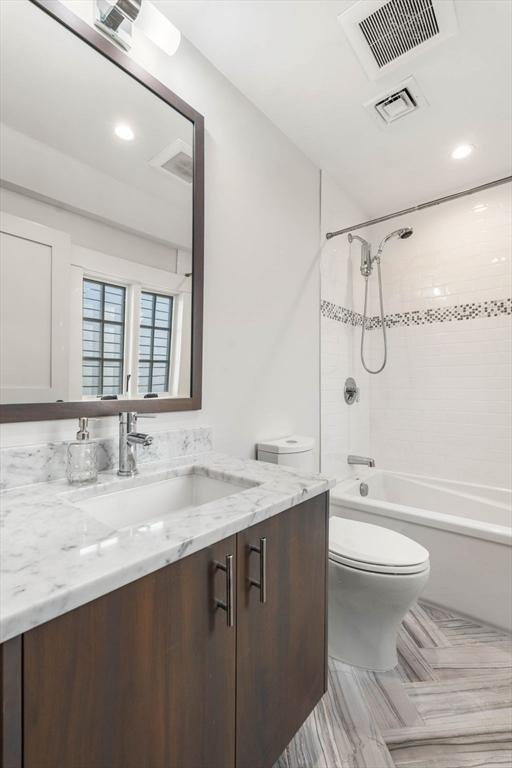 full bath featuring vanity, toilet, visible vents, and shower / bathtub combination