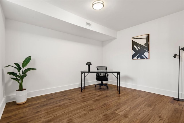 office space with wood finished floors, visible vents, and baseboards