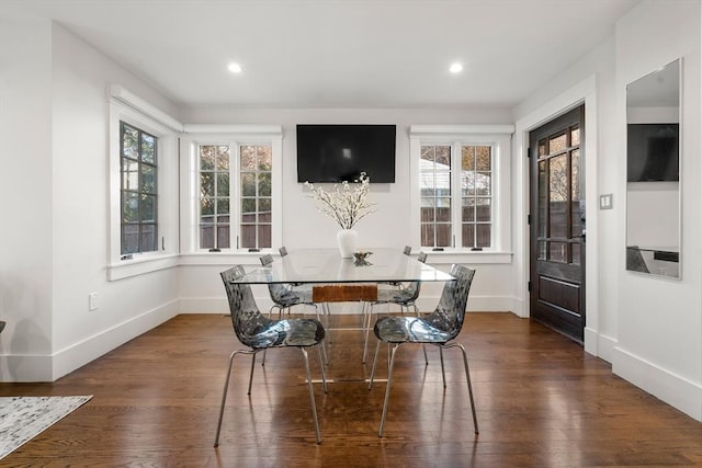 dining space featuring a healthy amount of sunlight, dark wood-type flooring, and baseboards