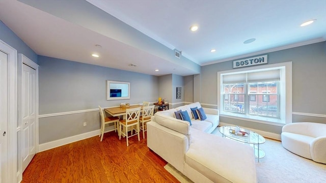 living area featuring visible vents, wood finished floors, baseboards, ornamental molding, and recessed lighting