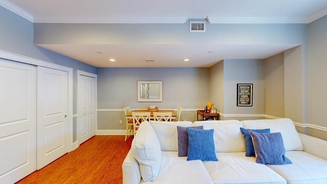 bedroom featuring visible vents, recessed lighting, multiple closets, and wood finished floors