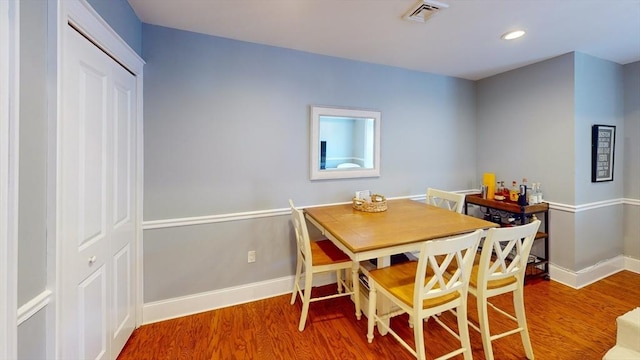 dining space with baseboards, recessed lighting, wood finished floors, and visible vents