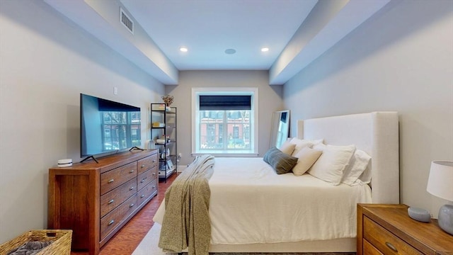 bedroom with recessed lighting, wood finished floors, and visible vents