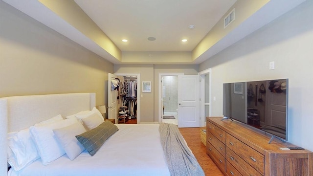 bedroom with connected bathroom, recessed lighting, a spacious closet, visible vents, and a closet