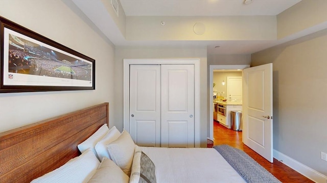 bedroom with a closet, baseboards, and wood finished floors