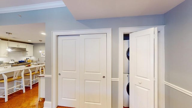 closet featuring stacked washer and dryer and a sink