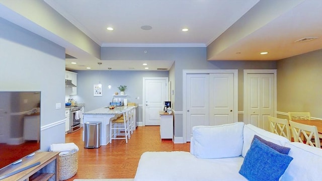 interior space featuring crown molding, recessed lighting, and light wood-type flooring