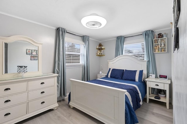 bedroom featuring light wood-type flooring, multiple windows, and ornamental molding