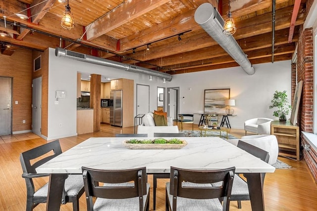 dining space featuring light wood-style flooring, visible vents, wood ceiling, baseboards, and beamed ceiling