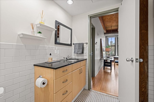 bathroom with wainscoting, tile walls, vanity, and tile patterned floors