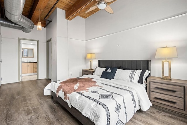 bedroom featuring beamed ceiling, wooden ceiling, wood finished floors, and a towering ceiling