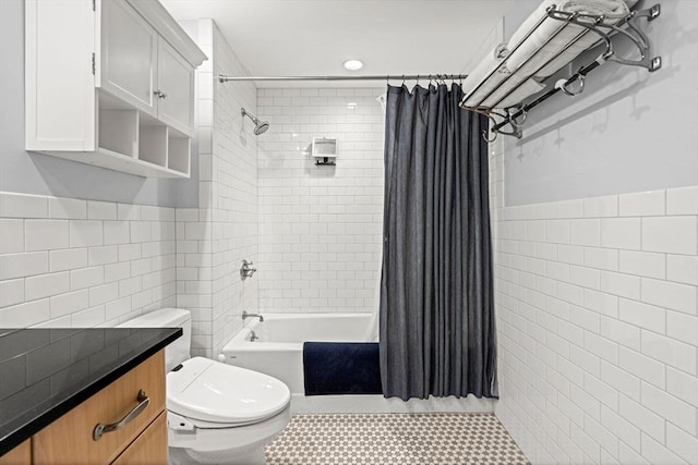 full bath with shower / tub combo, a wainscoted wall, tile walls, and toilet