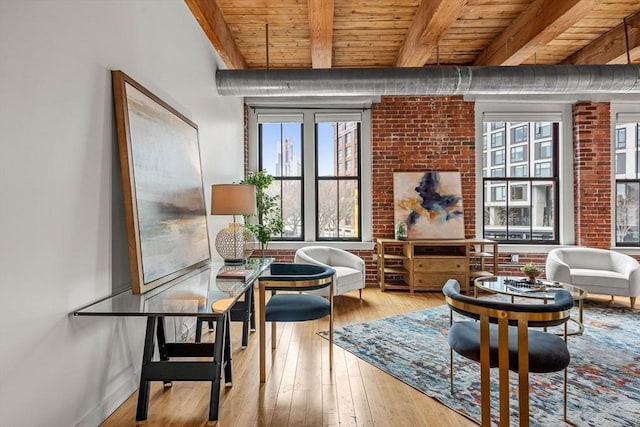 living area with wood ceiling, beam ceiling, wood-type flooring, and brick wall