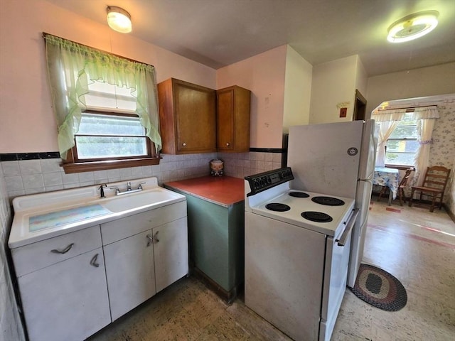 kitchen featuring light floors, electric range, light countertops, and brown cabinetry