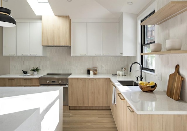 133 Fayerweather St Unit 1, Cambridge, MA 02138 - kitchen with electric stove, modern cabinets, light countertops, and light wood finished floors