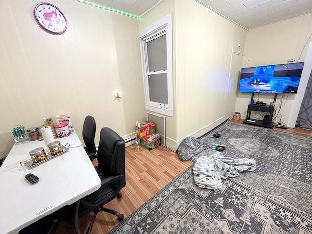 home office featuring baseboard heating and wood finished floors