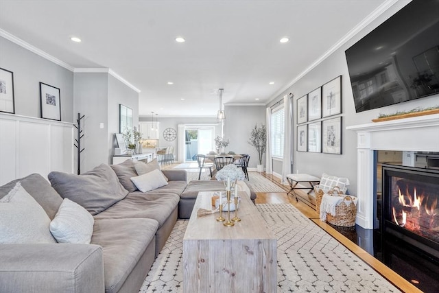 living room featuring ornamental molding and light hardwood / wood-style flooring