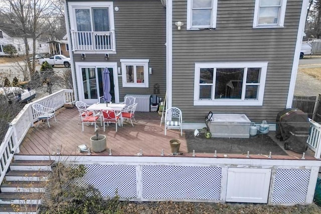 rear view of property with a wooden deck and outdoor dining space