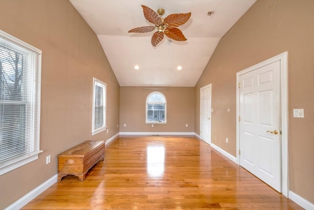 spare room with light wood finished floors, lofted ceiling, and baseboards