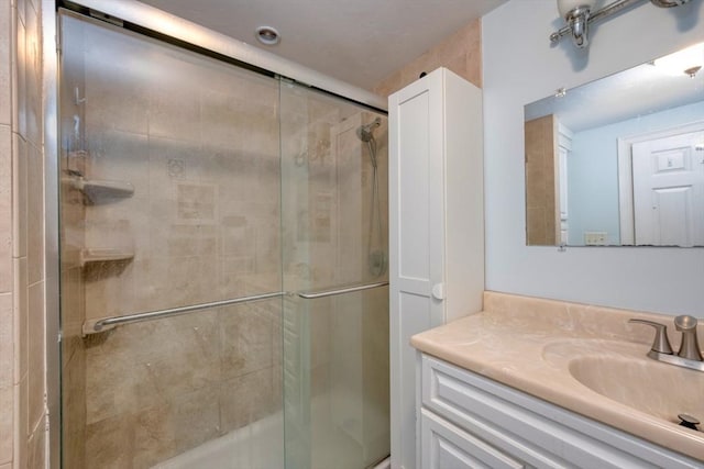 full bath featuring vanity and a shower stall