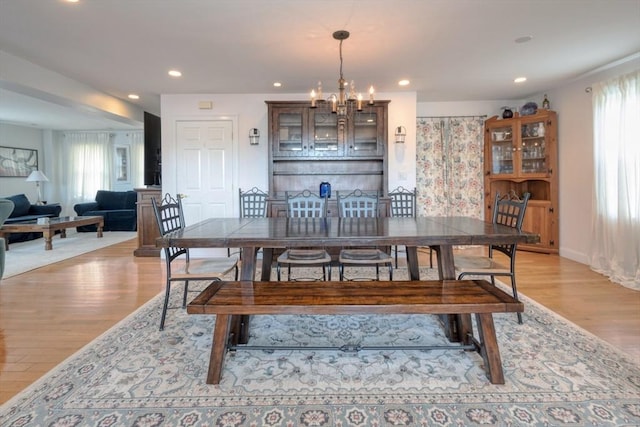 dining space with recessed lighting, a notable chandelier, and light wood finished floors