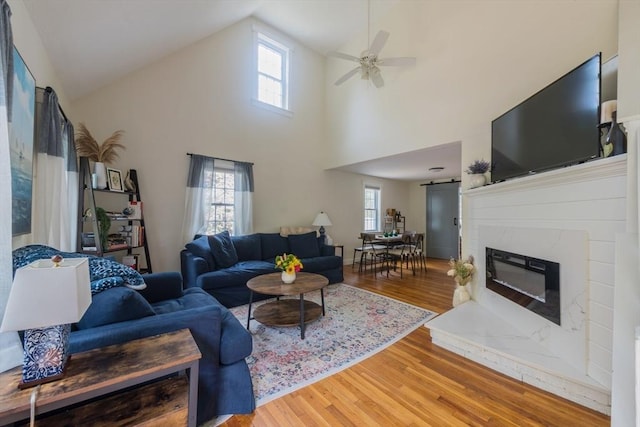 155 Great Marsh Rd, Barnstable, MA 02632 - living area featuring a ceiling fan, light wood-style flooring, plenty of natural light, high vaulted ceiling, and a fireplace