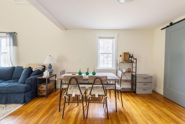 155 Great Marsh Rd, Barnstable, MA 02632 - dining room featuring a barn door, light wood-type flooring, and baseboards