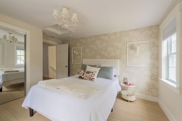 155 Great Marsh Rd, Barnstable, MA 02632 - bedroom with wallpapered walls, a chandelier, light wood finished floors, baseboards, and a closet
