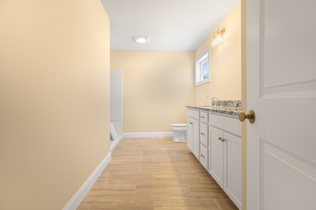 bathroom featuring vanity, hardwood / wood-style floors, and toilet