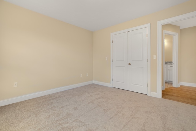 unfurnished bedroom featuring light colored carpet and a closet