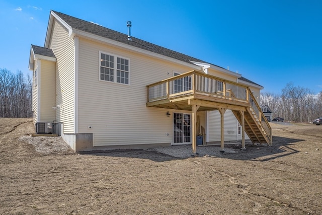 rear view of property featuring a wooden deck and central AC