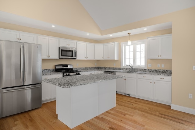 kitchen featuring light stone countertops, a kitchen island, white cabinets, and stainless steel appliances