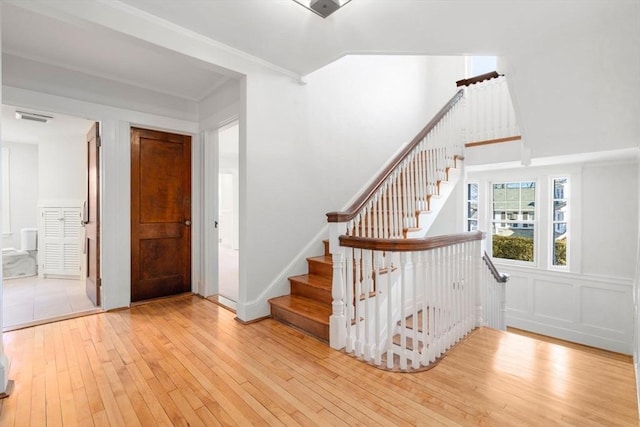 staircase featuring lofted ceiling, visible vents, and hardwood / wood-style flooring