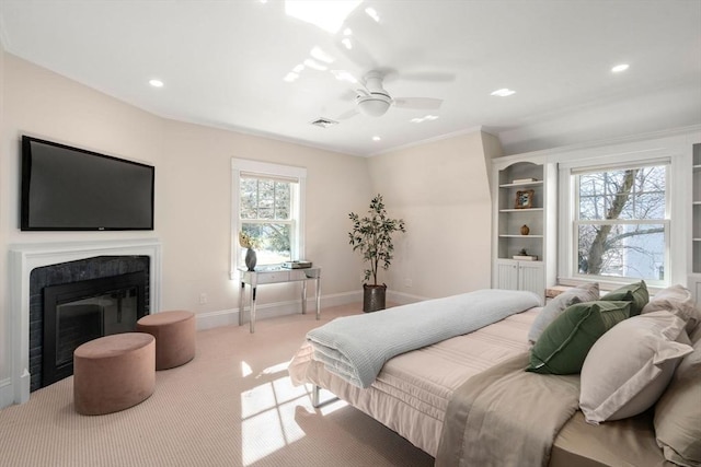 carpeted bedroom with visible vents, baseboards, a ceiling fan, a glass covered fireplace, and recessed lighting