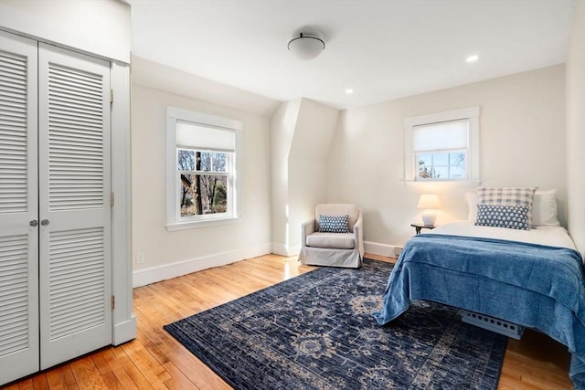 bedroom featuring a closet, recessed lighting, hardwood / wood-style flooring, and baseboards