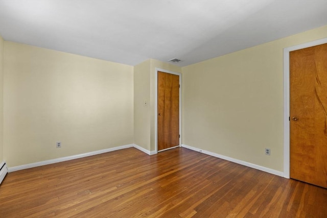 empty room featuring baseboards and wood finished floors