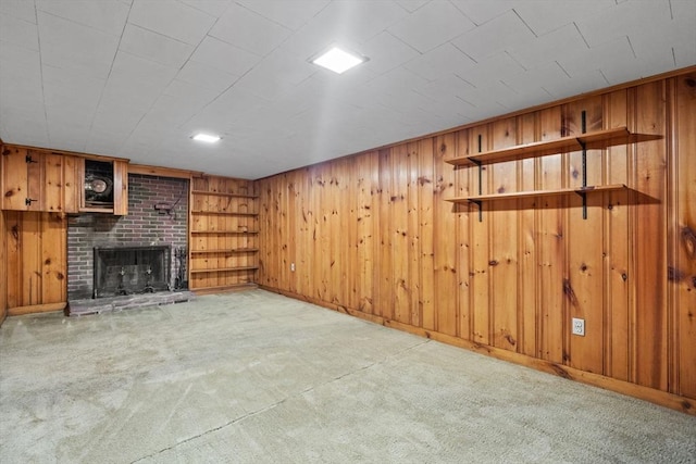 finished below grade area with carpet flooring, a fireplace, wooden walls, and baseboards