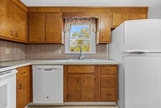 kitchen with white appliances, a sink, light countertops, and decorative backsplash
