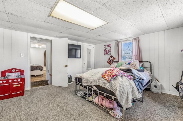 carpeted bedroom featuring a drop ceiling