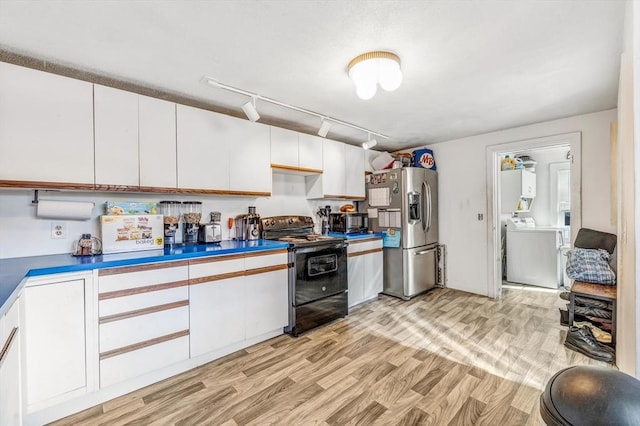 kitchen with washer / dryer, white cabinets, black range with electric stovetop, and stainless steel fridge