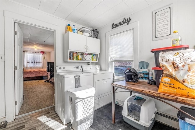 laundry area featuring wood finished floors, cabinet space, and washer and clothes dryer