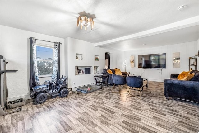 living room featuring baseboards, a chandelier, beam ceiling, wood finished floors, and a baseboard radiator