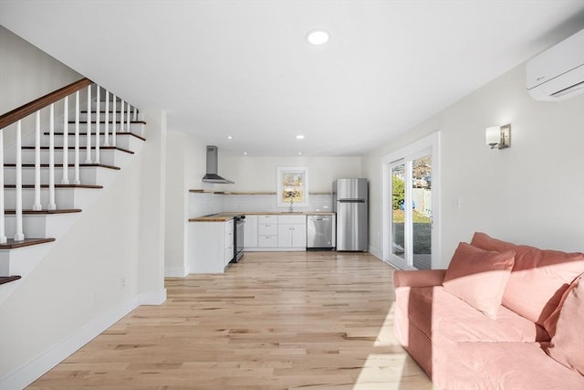 living room with light hardwood / wood-style flooring and a wall mounted AC