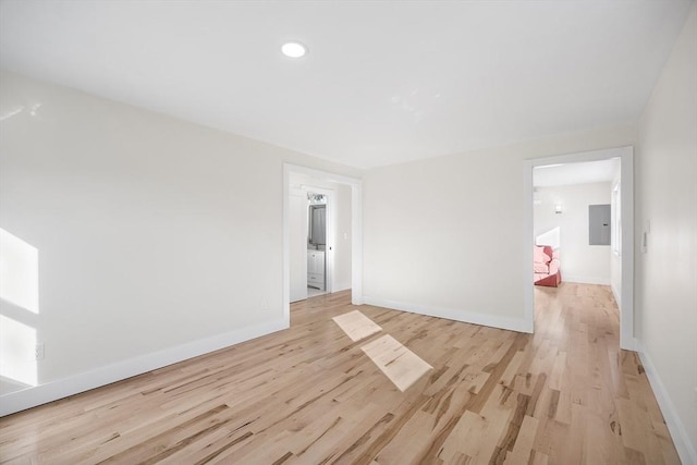 empty room with electric panel and light hardwood / wood-style flooring