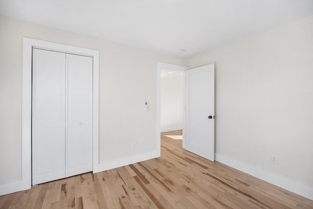 unfurnished bedroom featuring light hardwood / wood-style flooring and a closet