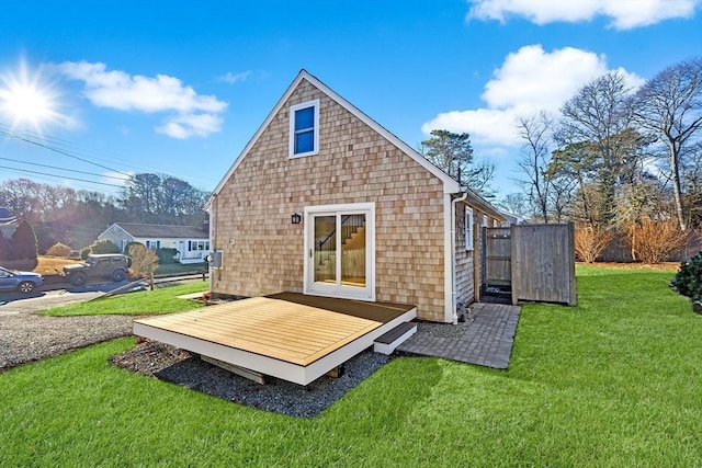 rear view of property featuring a lawn and a deck